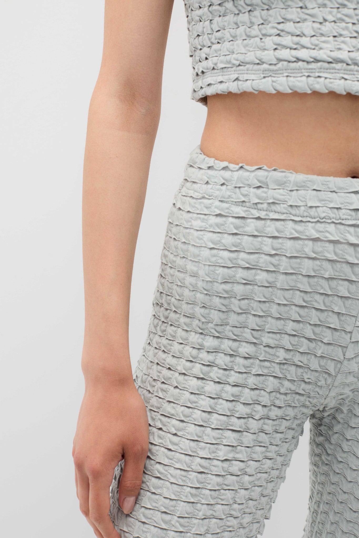 Textured gray top and pants on a plain background