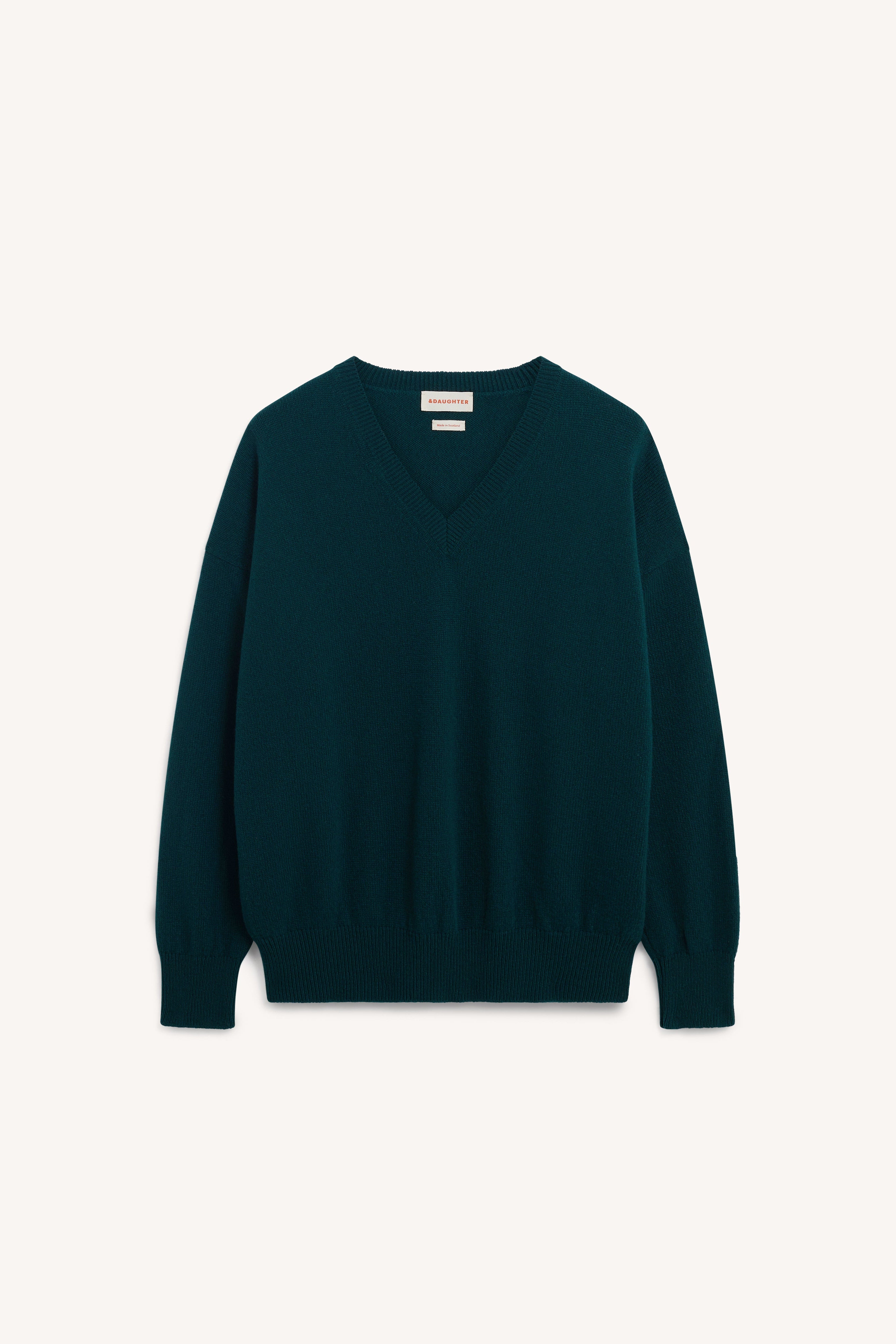 A dark teal green V-neck knit sweater with long sleeves and ribbed cuffs and hem, displayed flat against a light off-white background.