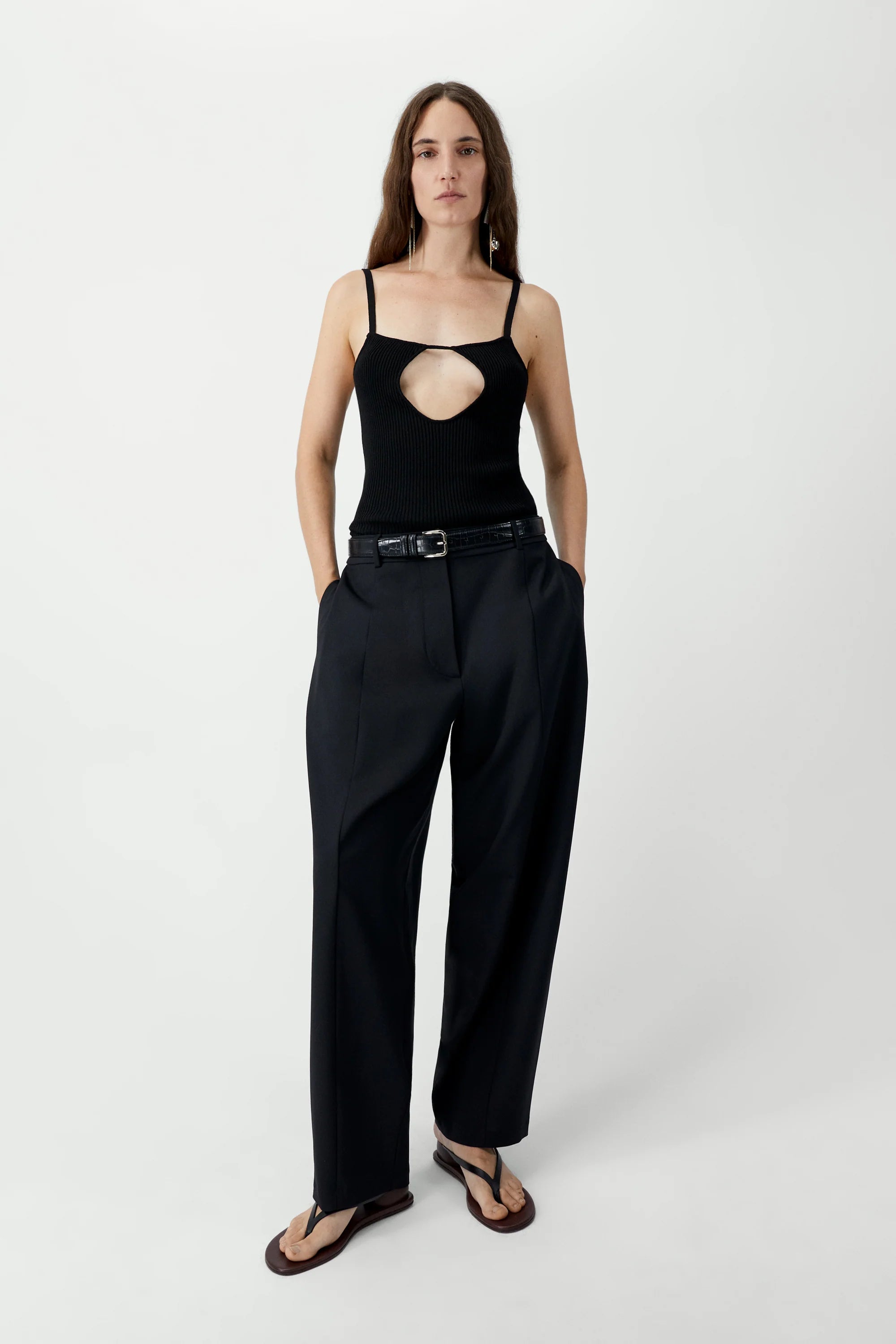 Woman wearing a black outfit with a cutout design on a white background