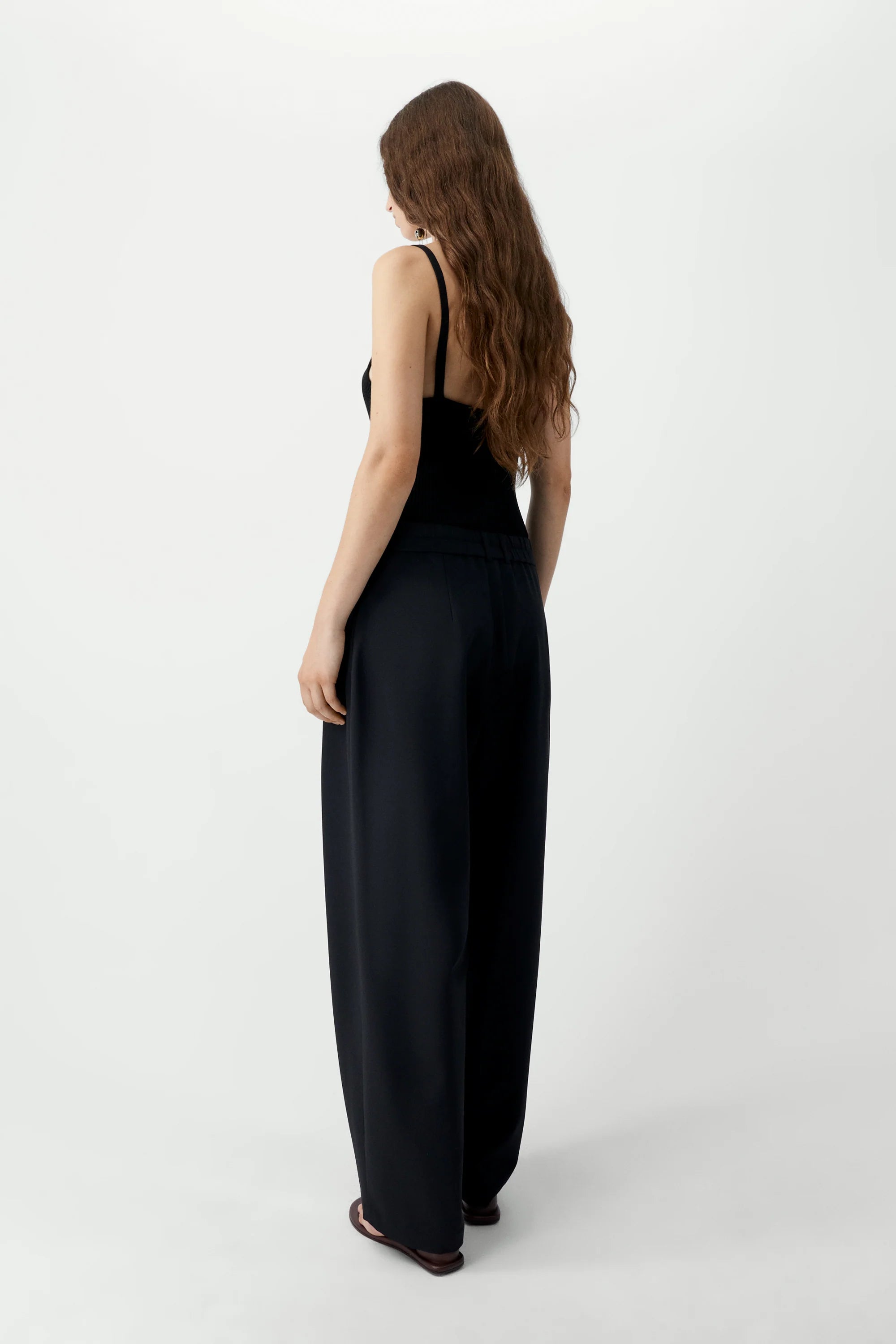 Woman wearing a black jumpsuit on a white background