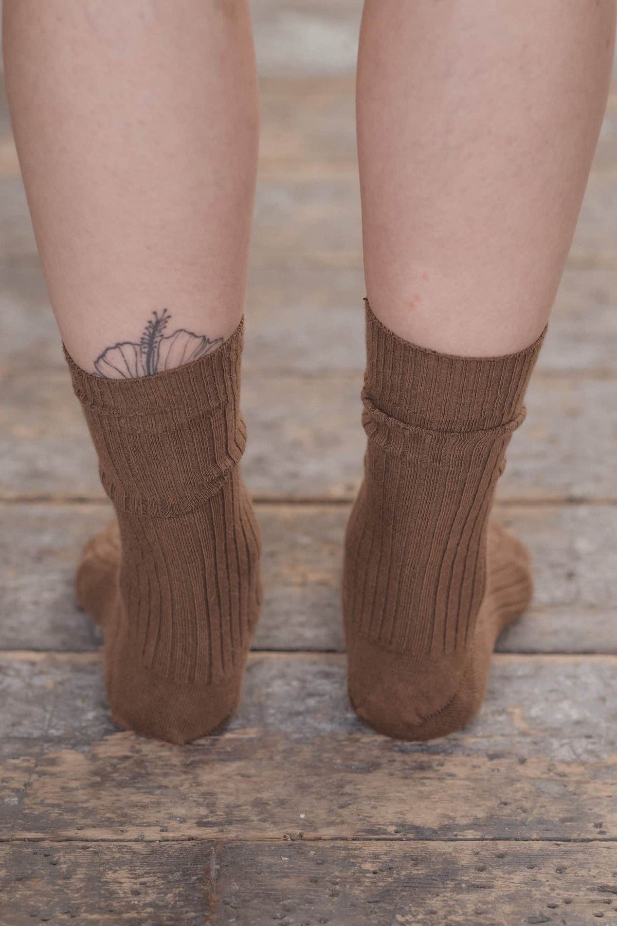 Brown socks worn on a wooden floor