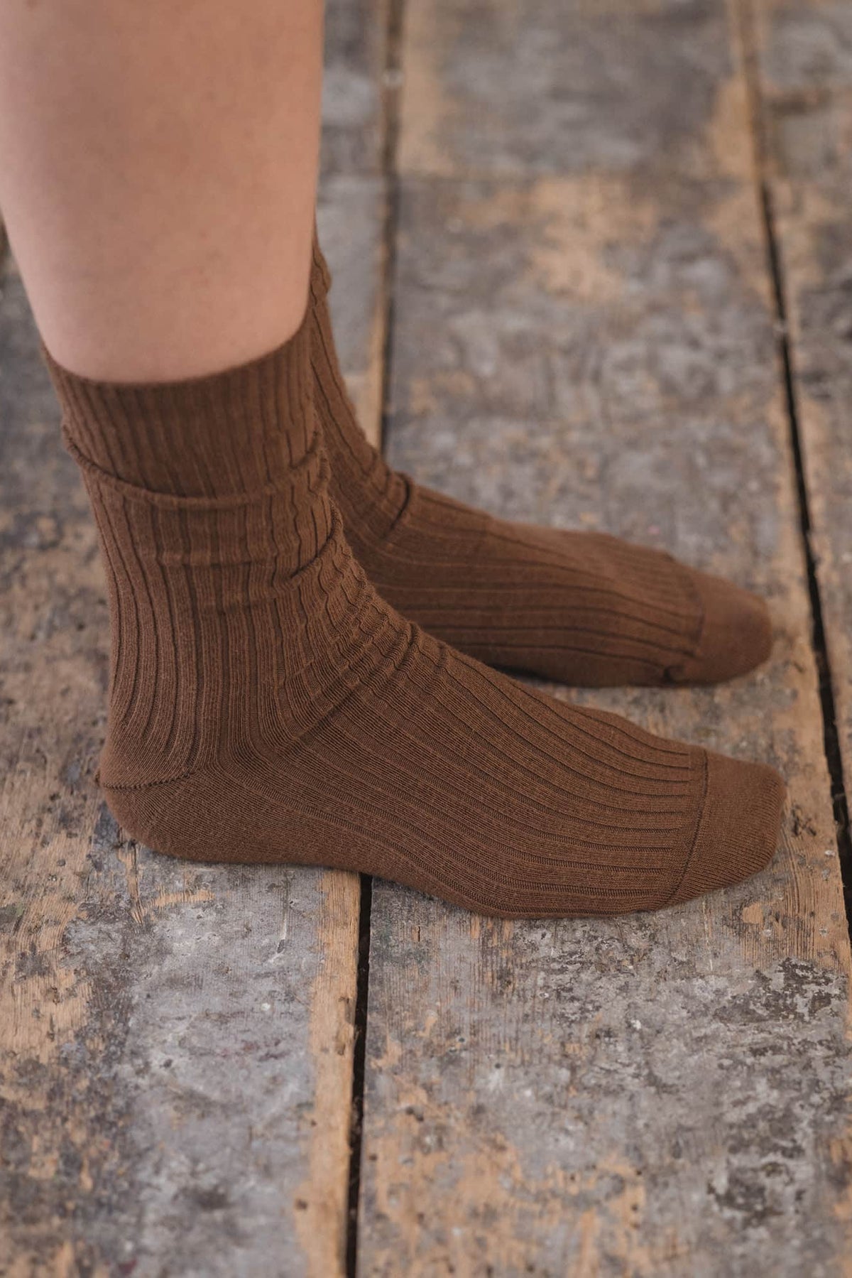 Brown socks worn on a wooden floor