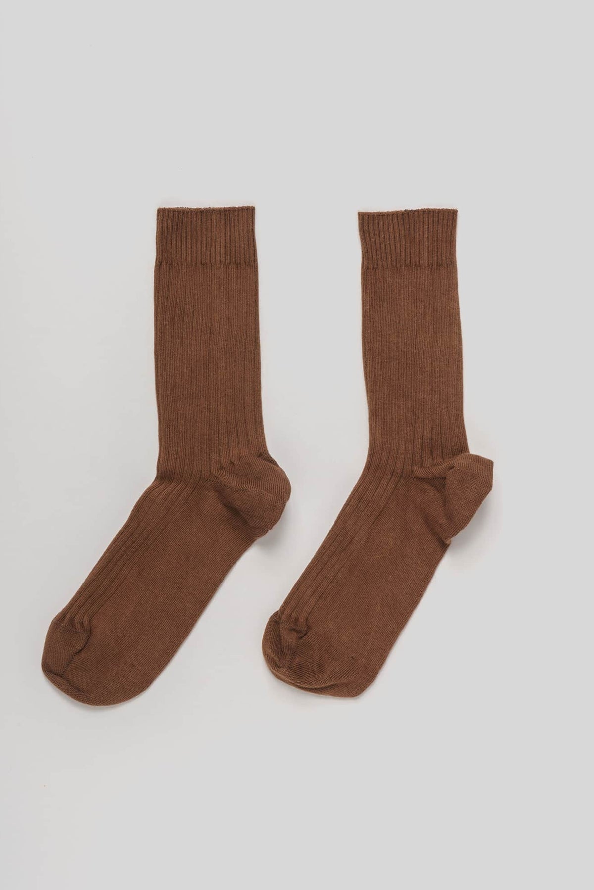 Pair of brown socks on a light gray background