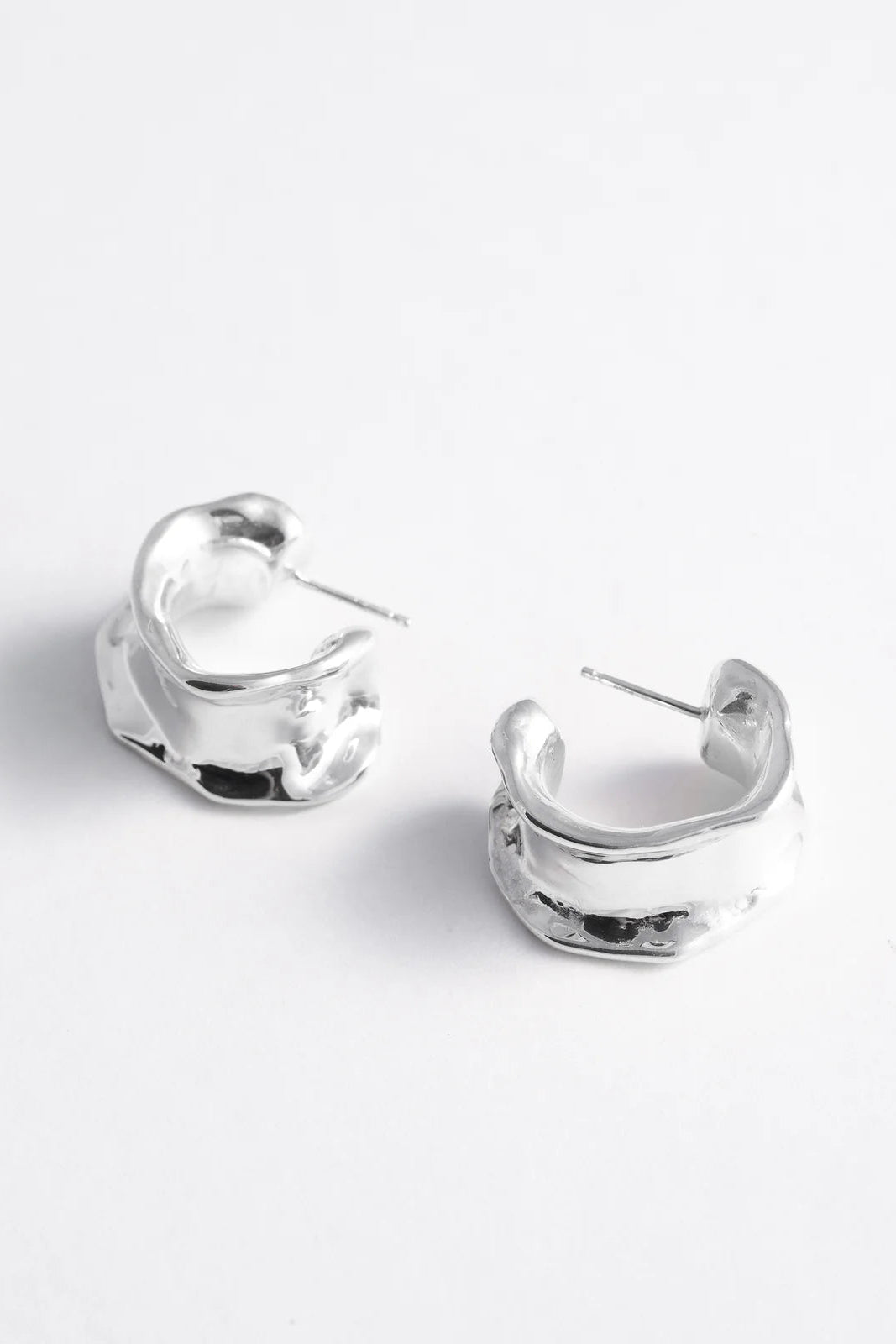 Pair of silver hoop earrings on a white background