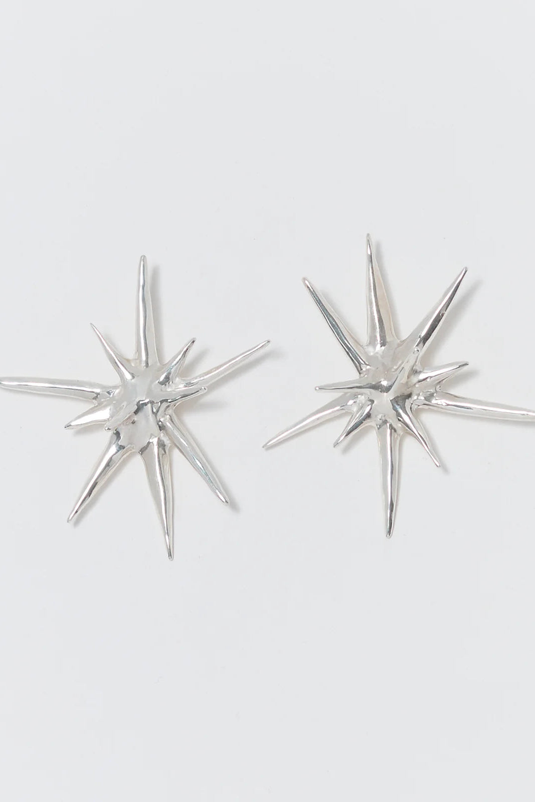 Silver star-shaped earrings on a white background