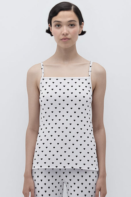 Woman wearing a polka dot top and pants on a white background