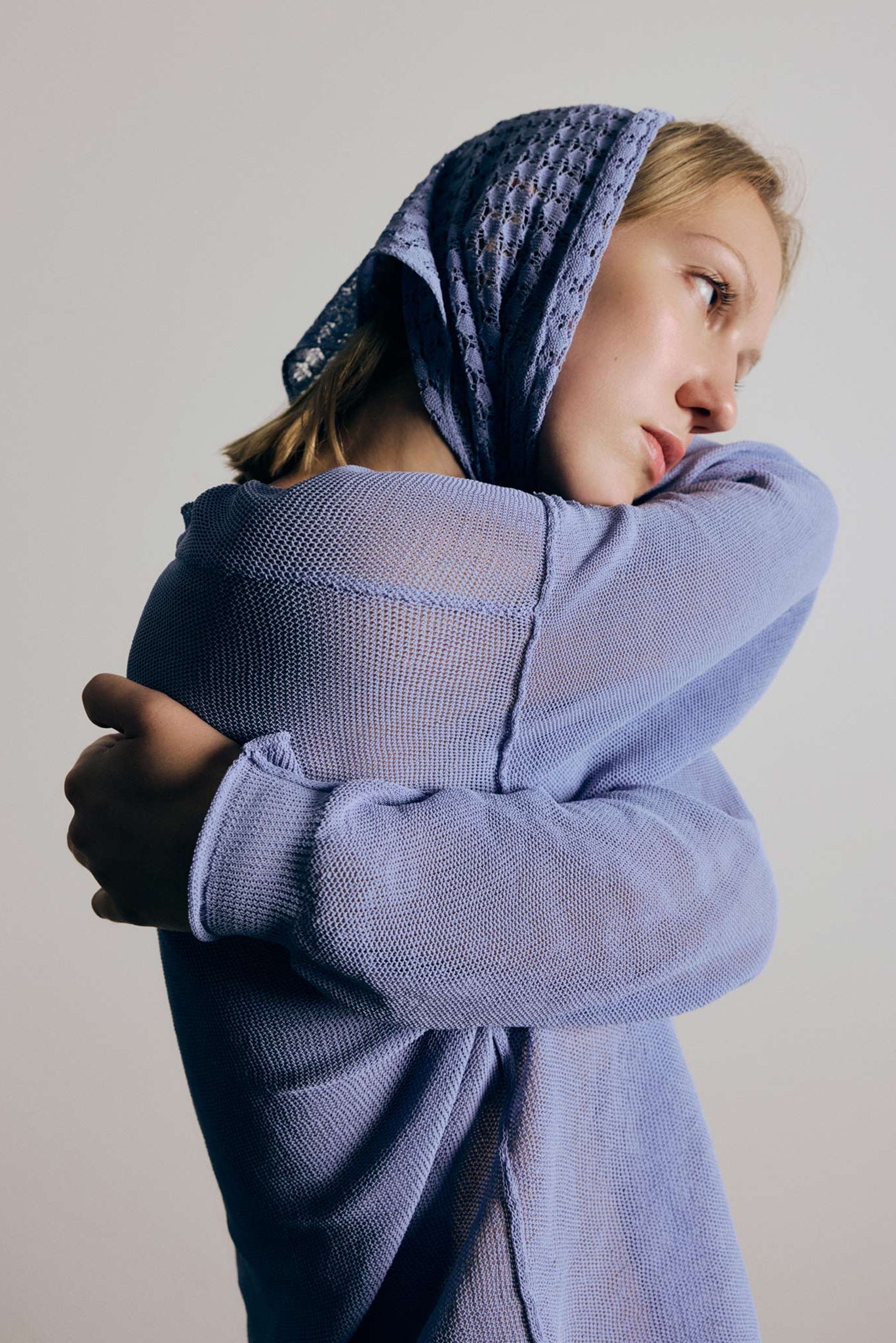 Woman wearing blue scarf on head and blue sweater