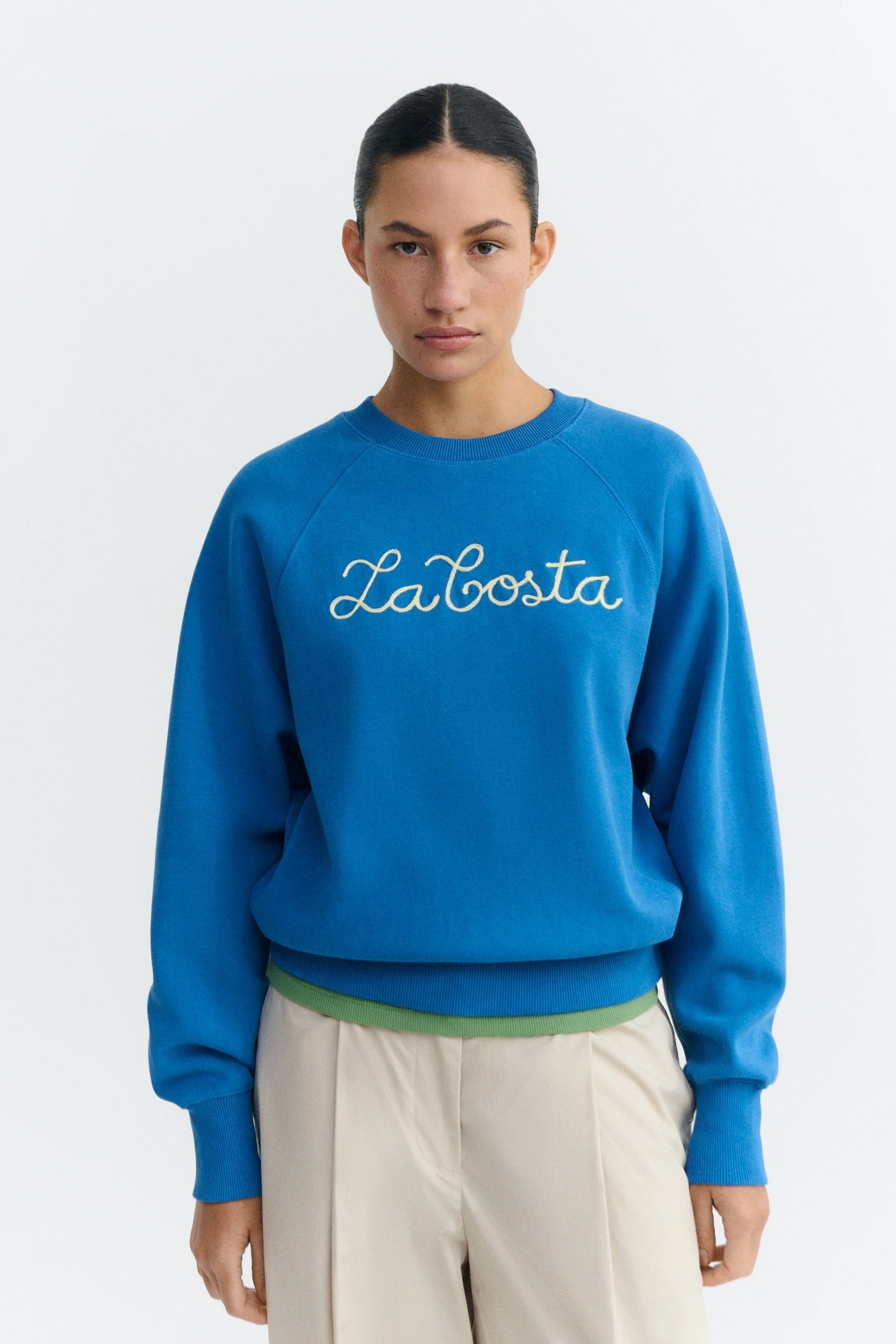 Person wearing a blue sweatshirt with 'La Bosta' branding on a white background