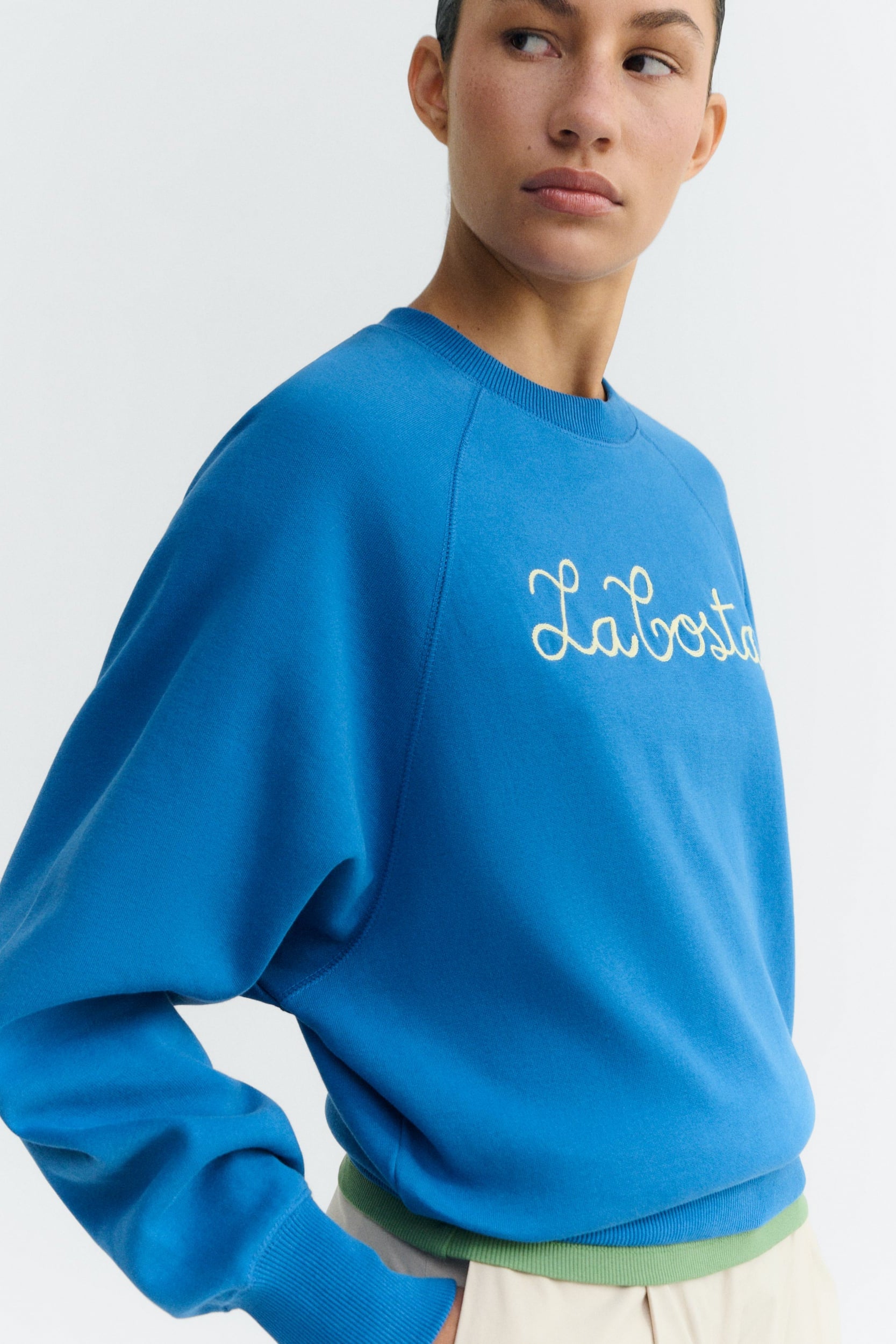 Person wearing a blue sweatshirt with 'La Boite' text on a white background