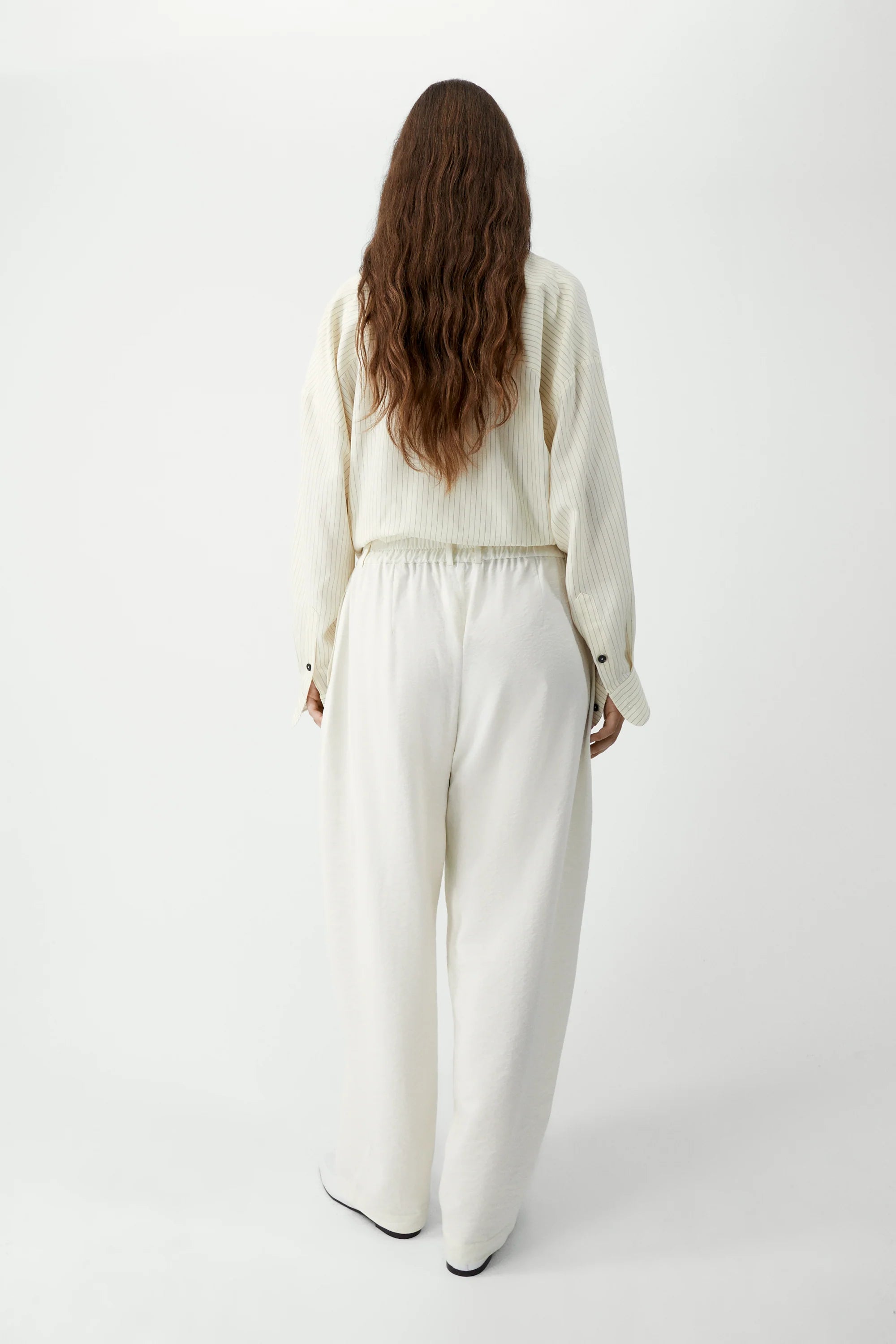 Person wearing a white outfit on a white background